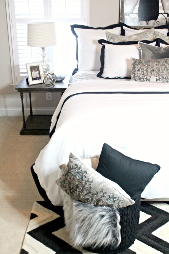 I love the use of mixed metals in this black, white and grey guest bedroom. The picture frame, accessories, and lamp all look like a cohesive grouping.
